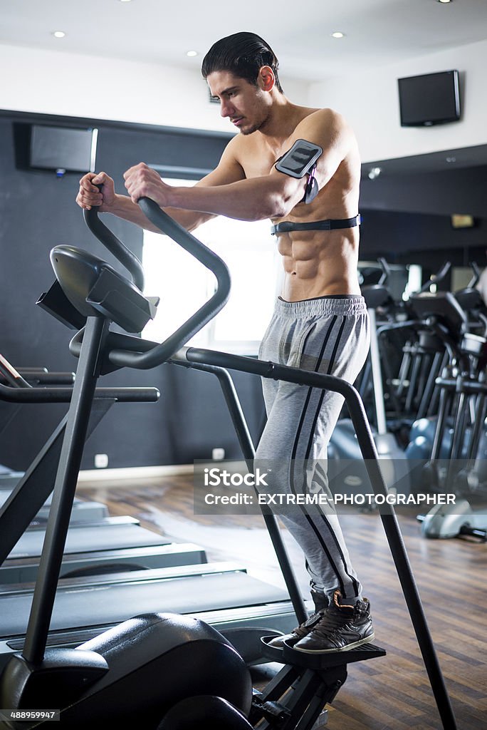 Step machine exercise Shirtless bodybuilder with pulse meter exercising on step machine in the gym. Stair Climbing Machine Stock Photo