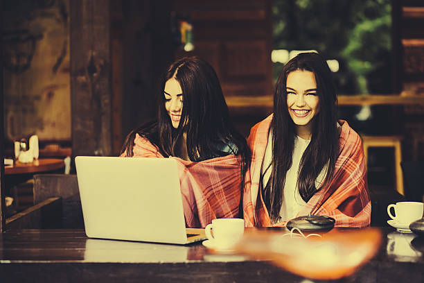istock two girls watching something in laptop 488960020