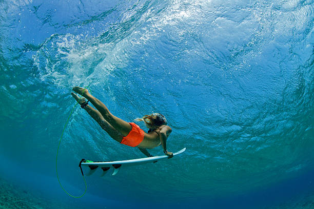 garota surfista em laranja short pato mergulhos uma onda - thruster - fotografias e filmes do acervo