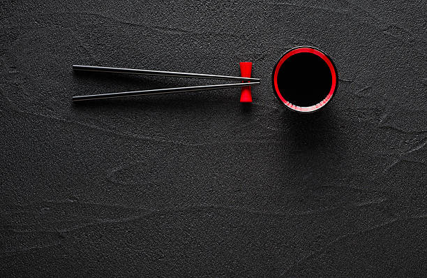 istock Chopsticks and bowl with soy sauce on black stone background 488960694