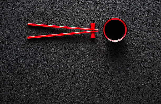 istock Chopsticks and bowl with soy sauce on black stone background 488960758