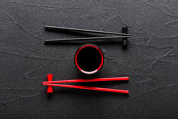 istock Chopsticks and bowl with soy sauce on black stone background 488961002