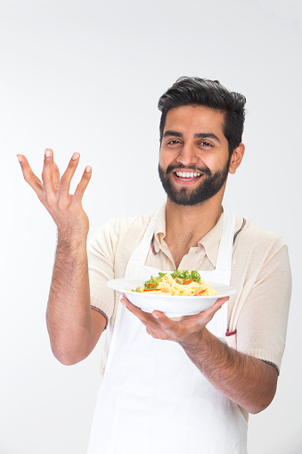 Indian man cooking Italian food