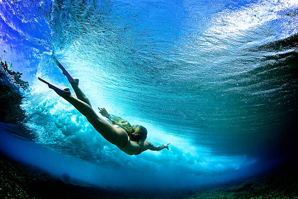 linda garota atrás de uma onda quebrando bodysurfs - bodysurfing - fotografias e filmes do acervo