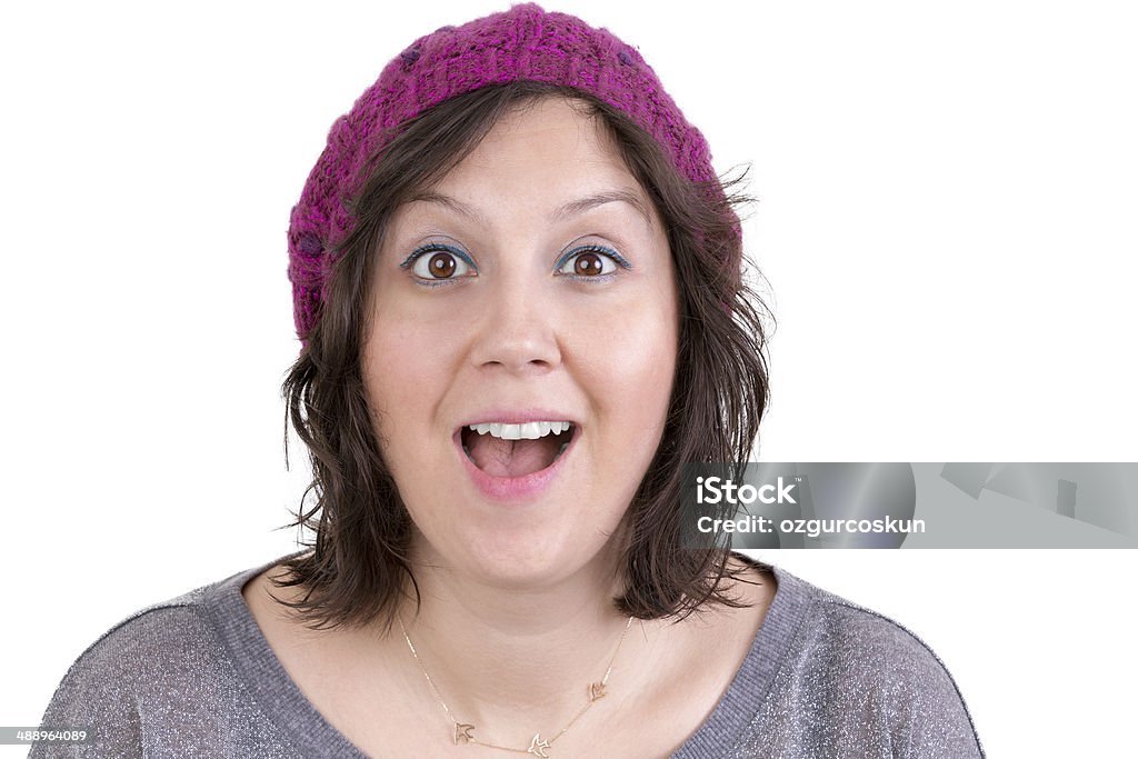Woman reacting in delight and pleasure Attractive woman in a knitted cap reacting in delight and pleasure with sparkling eyes and her mouth open wide, isolated on white Adult Stock Photo
