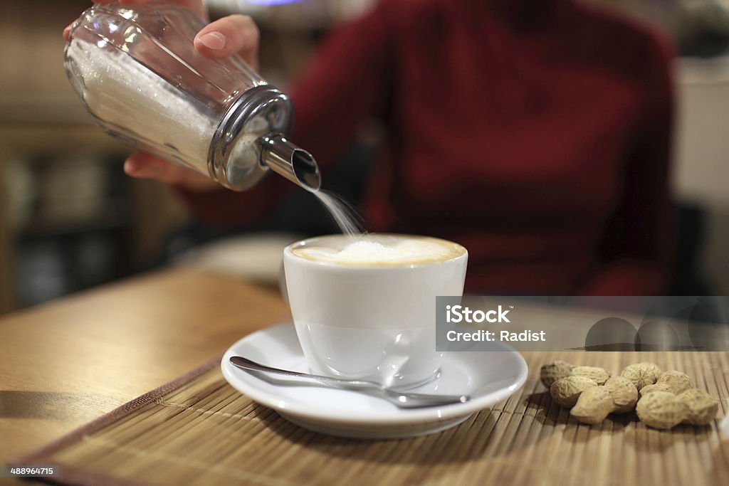 Person pours sugar in coffee Person pours sugar in coffee at a cafe Coffee - Drink Stock Photo