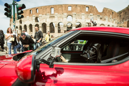 Rome, Italy - May 4, 2014: Star Wars Day 2014 in Rome: Darth Vader posing for a photograph for fans inside a red sport car in front of the Coliseum