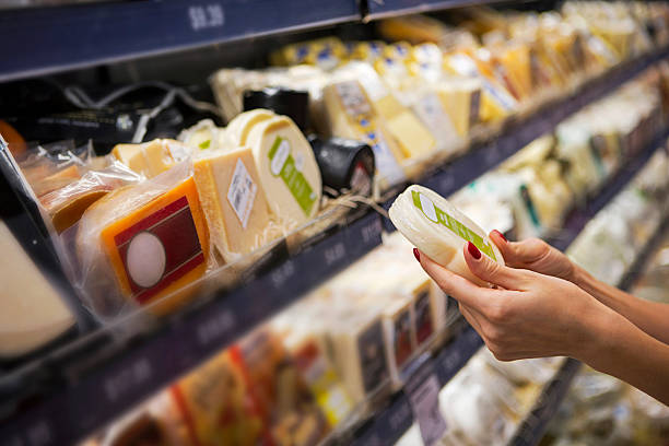 mulher comprando queijo ina supermercado - delicatessen - fotografias e filmes do acervo