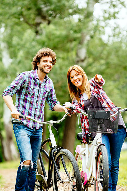istock Cheerful couple pushing bicycles and walking. 488977493
