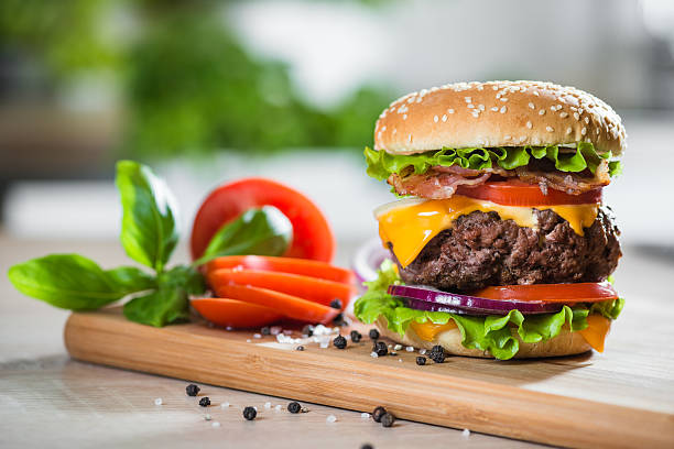 istock Home made huge Cheeseburger on oak chopping board 488978320