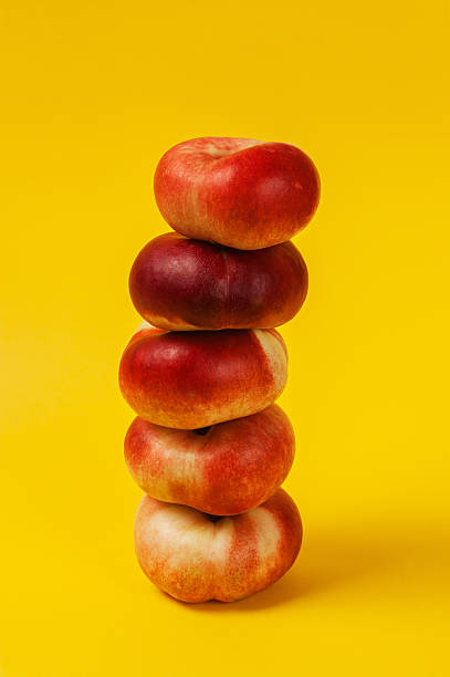 istock Pyramid of ripe nectarines on the yellow background 488978632