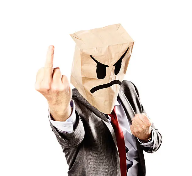 A mature businessman, in formal business clothes, wearing an angy-faced mask made from a paper bag, leans forward, making an obscene f... off gesture