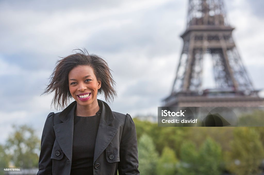 Happy Stylish Young African Woman By The Eiffel Tower Happy and stylish young African woman walking in Paris with the Eiffel Tower 20-29 Years Stock Photo