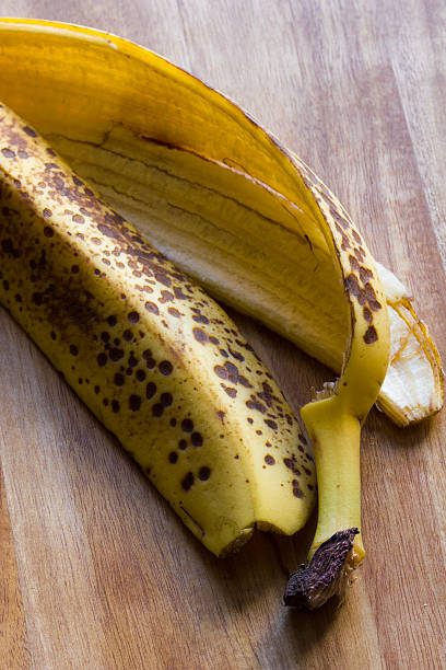 istock Banana skin on wooden board background with copy space 488979150