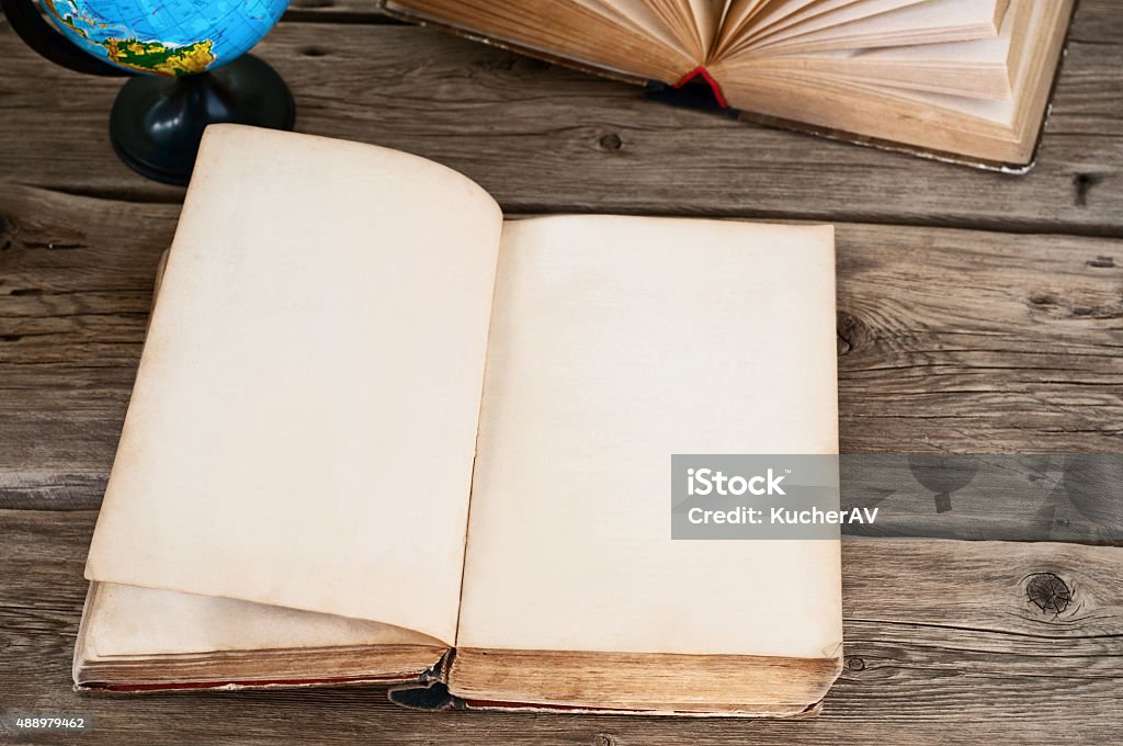 open old book with blank pages with globe closeup open old book with blank pages on wooden table with globe close up. Copy space. Free space for text Globe - Navigational Equipment Stock Photo