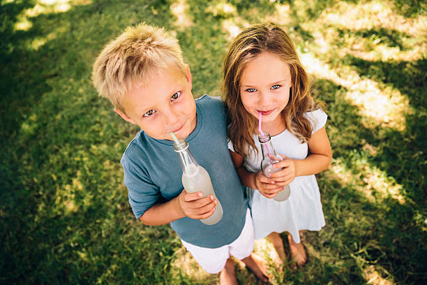 Sibling with drinks at park