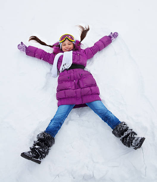 istock Girl laying star shape in snow 488979907