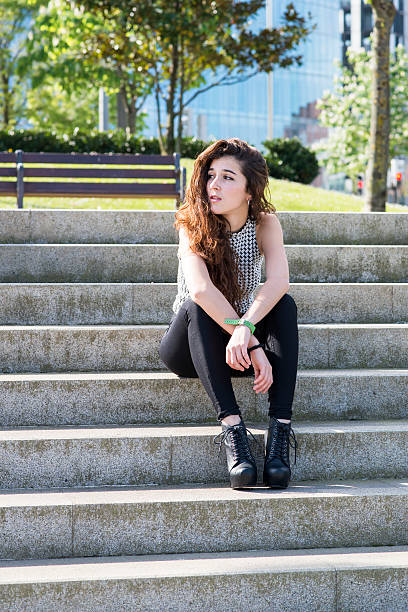 istock Attractive elegant woman sitting on stairs and looks away. 488980607