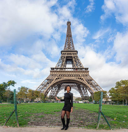 Happy and stylish young African woman in Paris with the Eiffel Tower