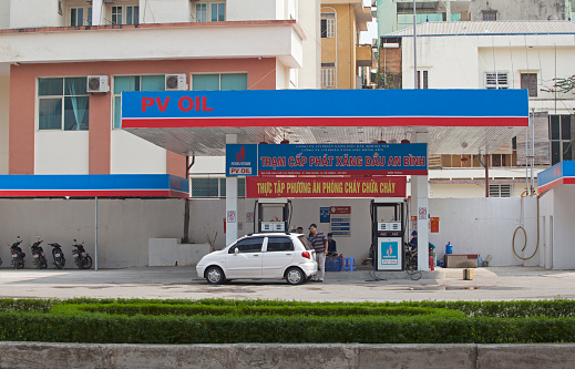 Hanoi, Vietnam - October 11, 2014: Vehicle stop to pump petrol at a gasoline station on the side of a street of Hanoi capital. Most of gasoline for sale in Vietnam is imported.