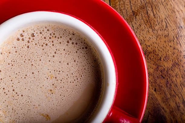 istock Frothy tea with saucer on wooden table 488984216