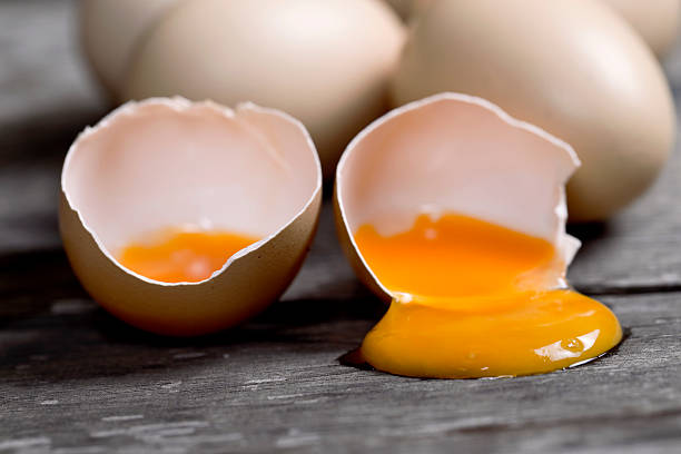 marrone uova con uova sul tavolo di legno incrinato - guscio duovo foto e immagini stock