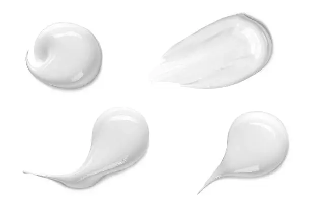 Collection of various strokes of a white beauty cream on white background