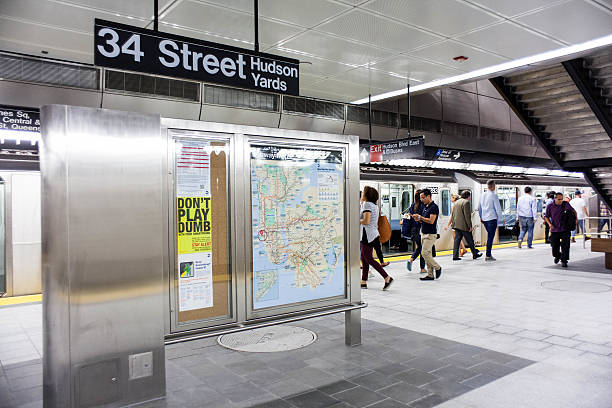 New York City, NY, USA - September 17, 2015: Commuters enter and exit the #7 train in the new Hudson Yards station. Subway map on board.