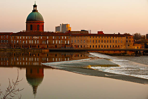 Sunset lights on the Garonne river with La Grave dome on the back, Toulouse, France