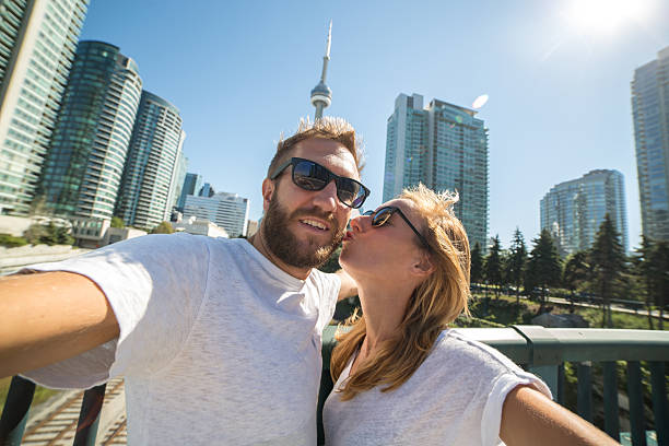 istock Young couple taking selfie portrait in Toronto using mobile phone 489001296