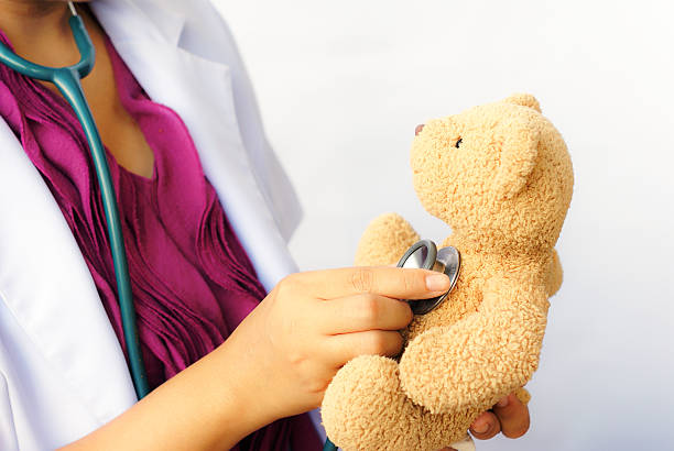 istock Female pediatrician examining a teddy bear with stethoscope 489003273