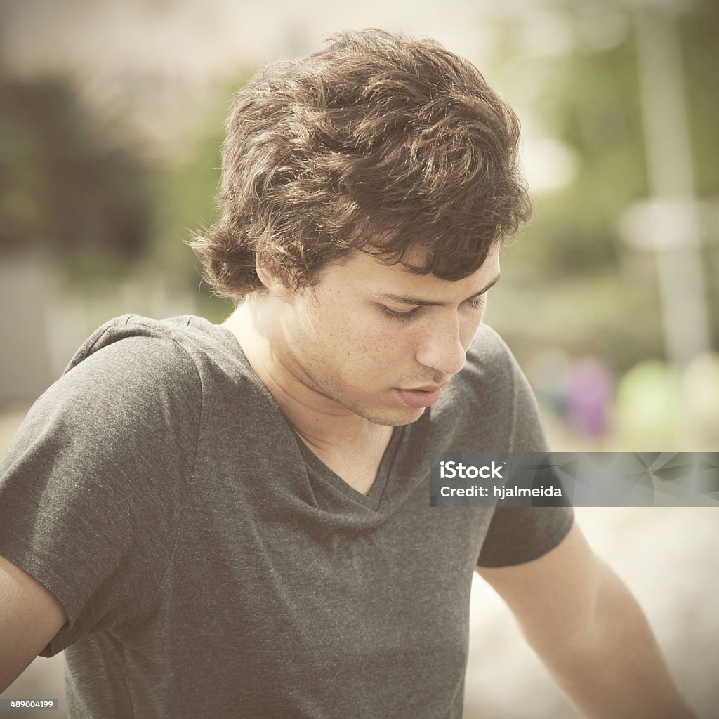 Sad young man sad teenager looking down in outdoor 16-17 Years Stock Photo
