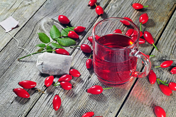 Dog rose tea Photo of dog rose tea on a wooden table wild rose hip stock pictures, royalty-free photos & images