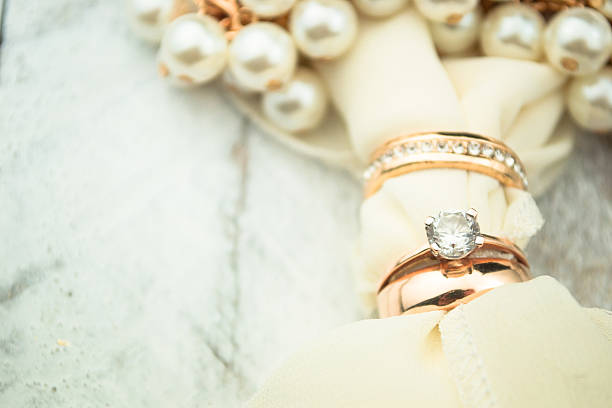istock Golden wedding rings on white wood background 489005966