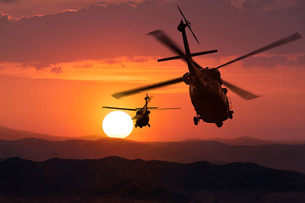istock Two flying army helicopters on sunset background 489010176