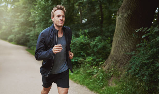 istock Healthy Man in Jacket Jogging at the Park 489010938