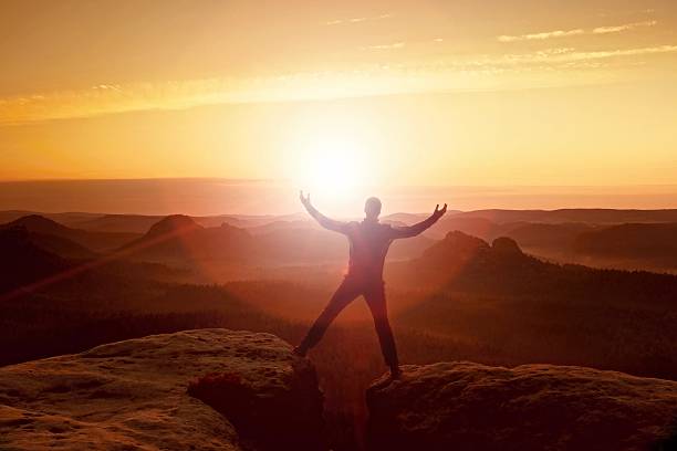 istock Jumping hiker in black celebrate triumph between two rocky peaks. 489013312
