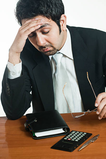 istock Disturbed businessman holding his head with headache, at working table. 489013536