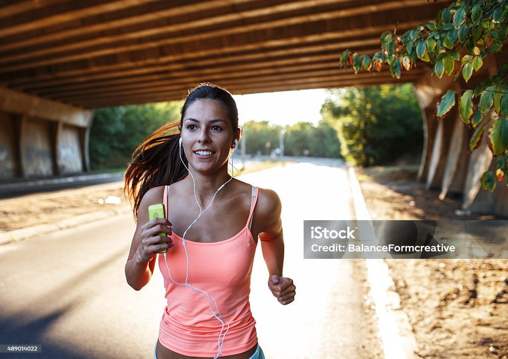 Jogging Female runner jogging in the city under the bridge. 2015 Stock Photo