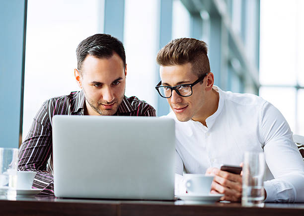istock Two young successful businessmen working on laptop in office building 489014622