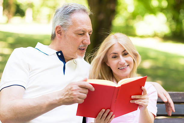 istock Mature couple reading a book in the park 489031348