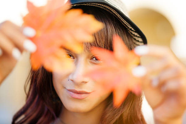 Young woman holding Autumn leafs in hands