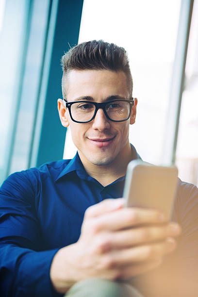 istock Cheerful young businessman using smartphone for communication and chat 489032922