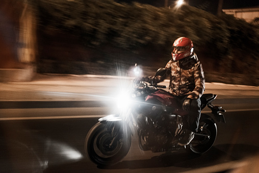 Izmir, Turkey - September 19, 2015: Motorcyclist man speeding in the street at night in Alsancak. Riding a Yamaha MT-07 Japanese motorbike.