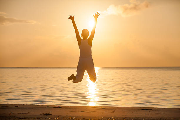 istock Happy young woman jumping on the beach 489038804