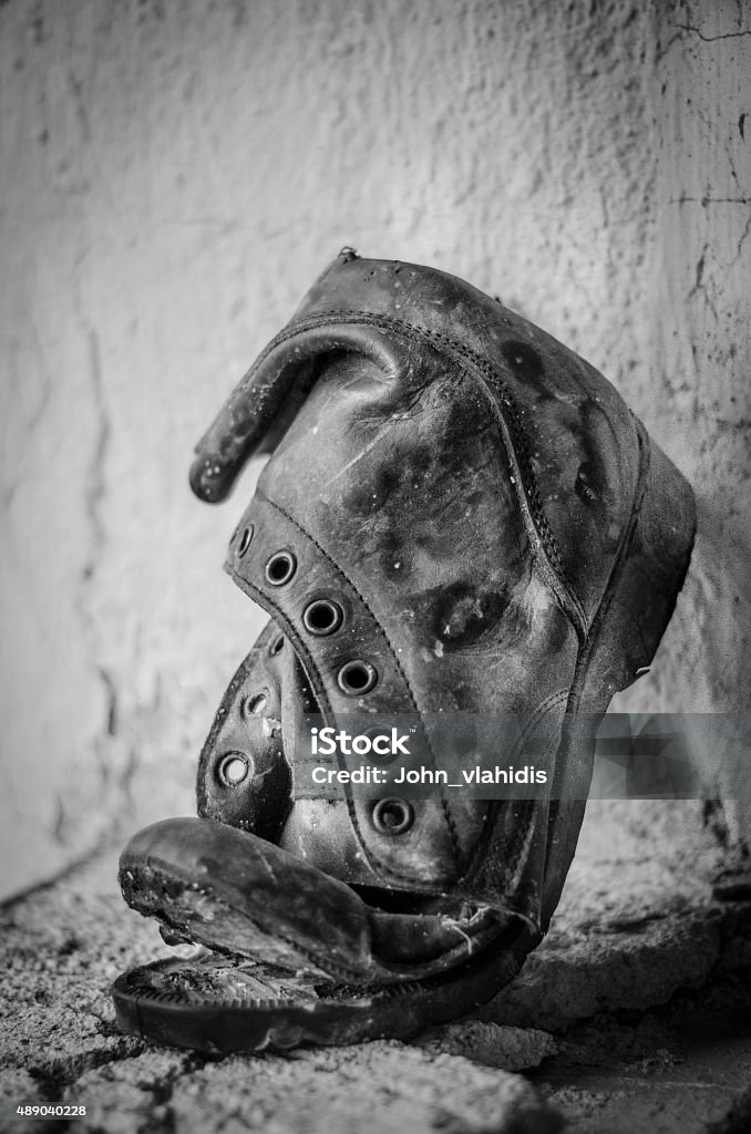 Old ripped boot Old ripped army boot relic and gravel 2015 Stock Photo