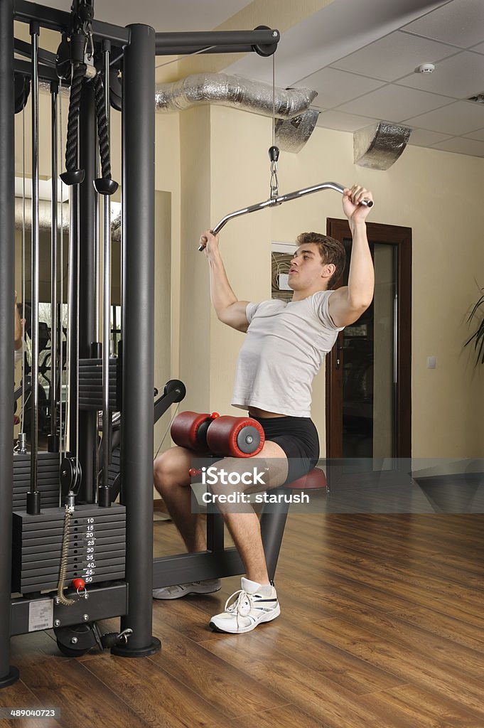 Hombre joven haciendo Letón desplegable rutina de ejercicios en el gimnasio - Foto de stock de Actividad libre de derechos