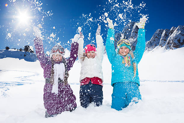 istock Three happy girls having fun with snow 489040955
