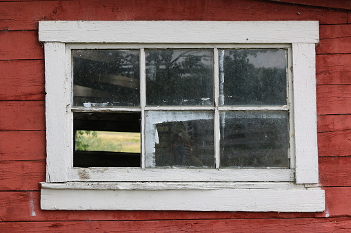 A white window from a red barn
