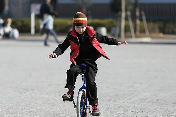 Boy to practice the unicycle in the park.
